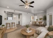 Thumbnail 5 of 23 - A living room with a white couch, a wooden coffee table, and a ceiling fan.