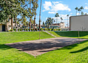 Thumbnail 8 of 16 - A large open area with a pathway and a green lawn.