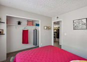 Thumbnail 18 of 24 - A bedroom with a pink bedspread and a red hanging towel.