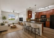 Thumbnail 5 of 27 - A modern kitchen with dark wood cabinets and a black refrigerator.