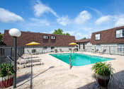Thumbnail 26 of 34 - A pool area with a blue pool and yellow umbrellas.