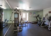 Thumbnail 28 of 34 - A gym with a variety of equipment including a treadmill, weights, and a bench press.