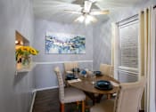 Thumbnail 5 of 34 - A dining room with a table set for two and a painting on the wall.