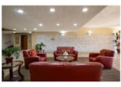 Thumbnail 21 of 36 - A living room with red couches and a white wallpaper.