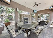 Thumbnail 9 of 27 - A patio with a table, chairs, and a fireplace.