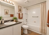 Thumbnail 10 of 45 - A bathroom with a white toilet, sink, and shower.