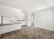 Thumbnail 1 of 42 - A kitchen with white cabinets and a wooden floor.