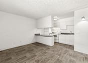 Thumbnail 2 of 42 - A kitchen with white cabinets and a wooden floor.