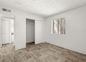 Thumbnail 6 of 42 - A room with a wooden floor and a painting on the wall.
