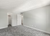 Thumbnail 15 of 42 - A room with grey carpet and white walls with two open doors.