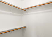 Thumbnail 18 of 42 - A white wall with a brown shelf and a grey carpet.