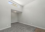 Thumbnail 10 of 42 - A room with a grey carpet and a window.