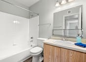 Thumbnail 17 of 42 - A white bathroom with a toilet, sink, and bathtub.