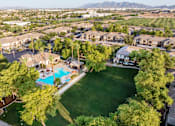 Thumbnail 14 of 25 - A bird's eye view of a neighborhood with a swimming pool and green lawns.