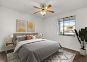Thumbnail 11 of 25 - A bedroom with a bed, a ceiling fan, and a window.