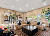 Thumbnail 17 of 25 - A living room with a couch, coffee table, and potted plants.