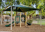 Thumbnail 19 of 25 - A playground with a green slide and a canopy.