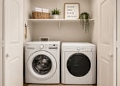 Thumbnail 7 of 26 - Two washing machines in a small laundry room.