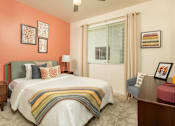 Thumbnail 4 of 12 - A bedroom with a bed, nightstand, and chair.