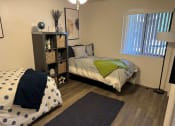 Thumbnail 3 of 23 - a bedroom with a bed and a nightstand and a window