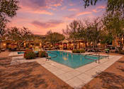Thumbnail 2 of 27 - A pool surrounded by trees and a building in the background.