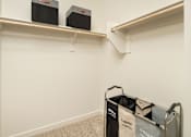 Thumbnail 5 of 12 - A room with two shelves and a laundry basket.