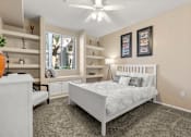 Thumbnail 21 of 23 - A bedroom with a large bed, a dresser, and a window with a view of trees.