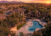Thumbnail 3 of 23 - A sunset view of a residential area with a swimming pool.
