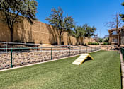 Thumbnail 9 of 19 - A playground with a yellow slide and green grass.