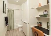 Thumbnail 6 of 12 - A bathroom with a toilet, sink, and shower.