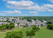 Thumbnail 56 of 64 - A bird's eye view of a residential area with houses and greenery.