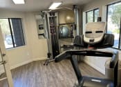 Thumbnail 14 of 23 - a gym with a treadmill and a chair in it