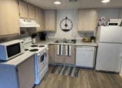 Thumbnail 1 of 23 - a kitchen with white appliances and a clock on the wall