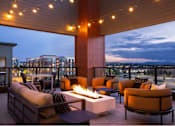 Thumbnail 1 of 28 - A patio with a fire pit and seating area.