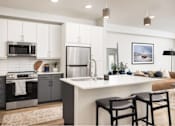Thumbnail 19 of 28 - A modern kitchen with a large island and bar stools.
