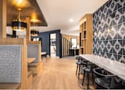 Thumbnail 17 of 28 - A modern restaurant with wooden floors and bar stools.
