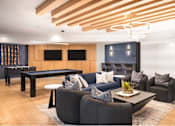 Thumbnail 14 of 28 - A modern living room with a pool table and a fireplace.