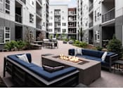 Thumbnail 4 of 28 - A patio with a fire pit and seating area.