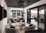 Thumbnail 3 of 28 - A modern living room with a glass door leading to a balcony.