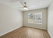 Thumbnail 34 of 38 - Empty room with a ceiling fan and a window with blinds.