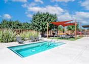 Thumbnail 20 of 45 - A pool with a red canopy and lounge chairs.