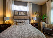 Thumbnail 7 of 45 - A bedroom with a large bed and a chair.