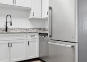 Thumbnail 6 of 25 - A kitchen with a white fridge and cabinets.
