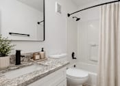 Thumbnail 14 of 25 - A white bathroom with a sink, toilet, and shower.