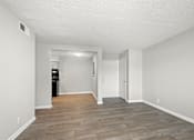 Thumbnail 9 of 26 - A room with a wooden floor and white walls.