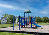 Thumbnail 19 of 26 - A playground with a blue slide and a green roofed structure.