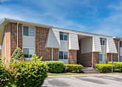 Thumbnail 21 of 26 - A row of townhouses with a clear blue sky above.