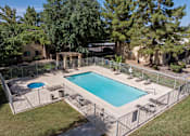 Thumbnail 10 of 17 - A pool surrounded by a fence and trees.