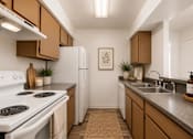 Thumbnail 4 of 17 - A kitchen with brown cabinets and a white stove.