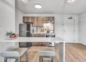 Thumbnail 4 of 37 - a kitchen with stainless steel appliances and wooden cabinets at The Meriden, Meriden Connecticut